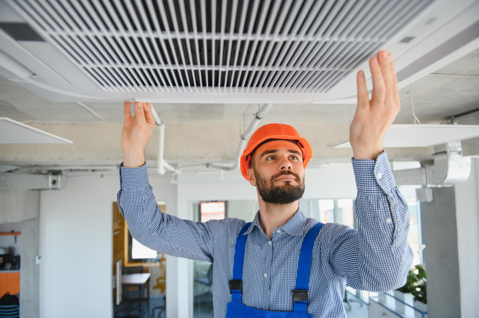 an hvac technician in vernon bc installing a new ac unit in a commercial building